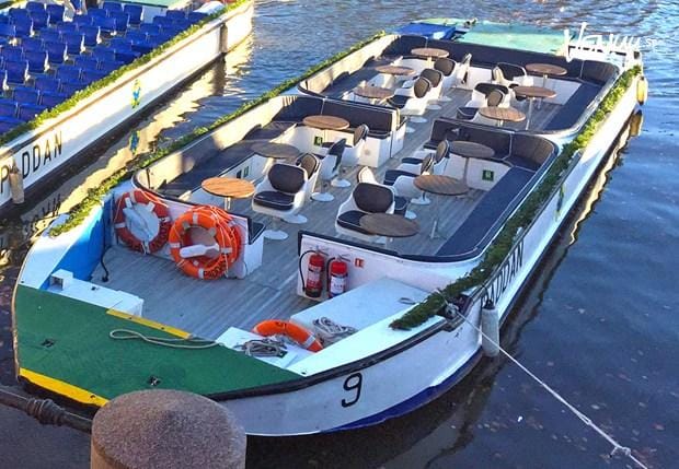  En unik och modern paddan-båt med lounge-sittningar och fönster, anpassad för fester på kanalen.