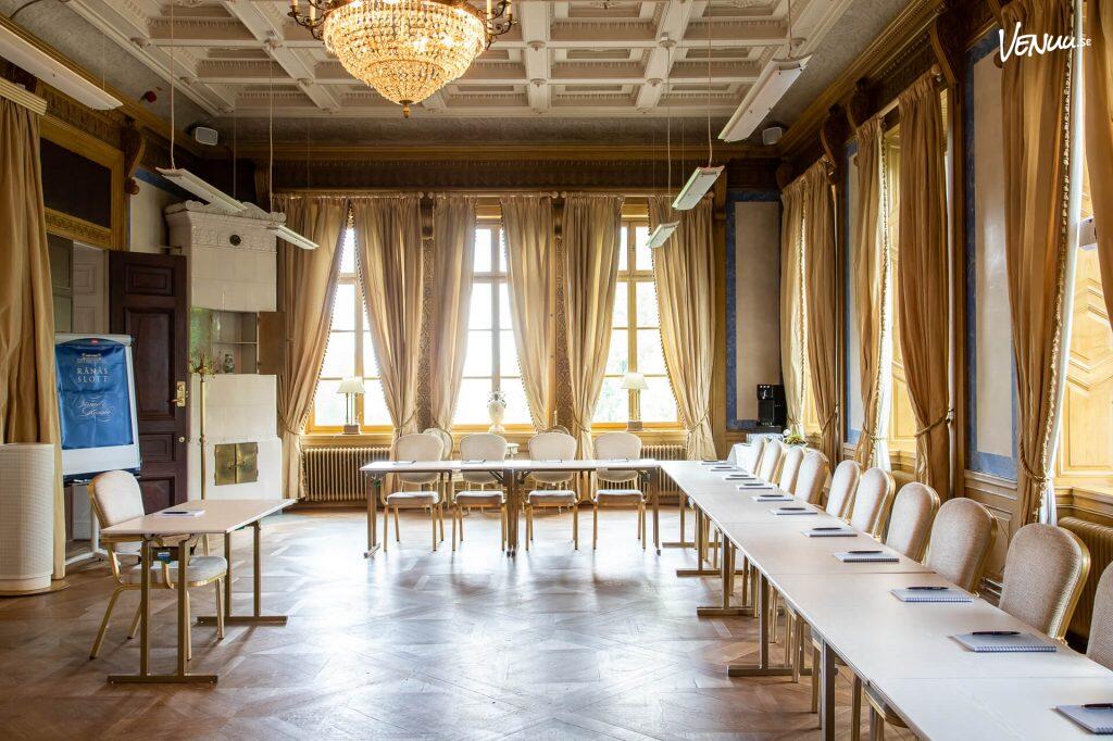 Ett pampigt och lyxigt konferensrum i ett slott, med anrik inredning och historiska detaljer.