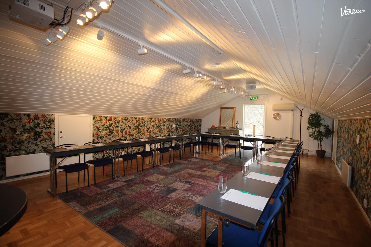 Ett mysigt mötesrum med herrgårdskänsla och utsikt över en grönskande park.