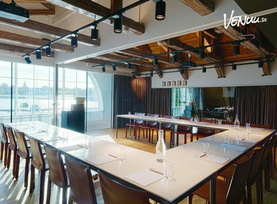 En unik konferenslokal på Spritmuseum med spännande utställningsdetaljer i bakgrunden och en modern inredning.