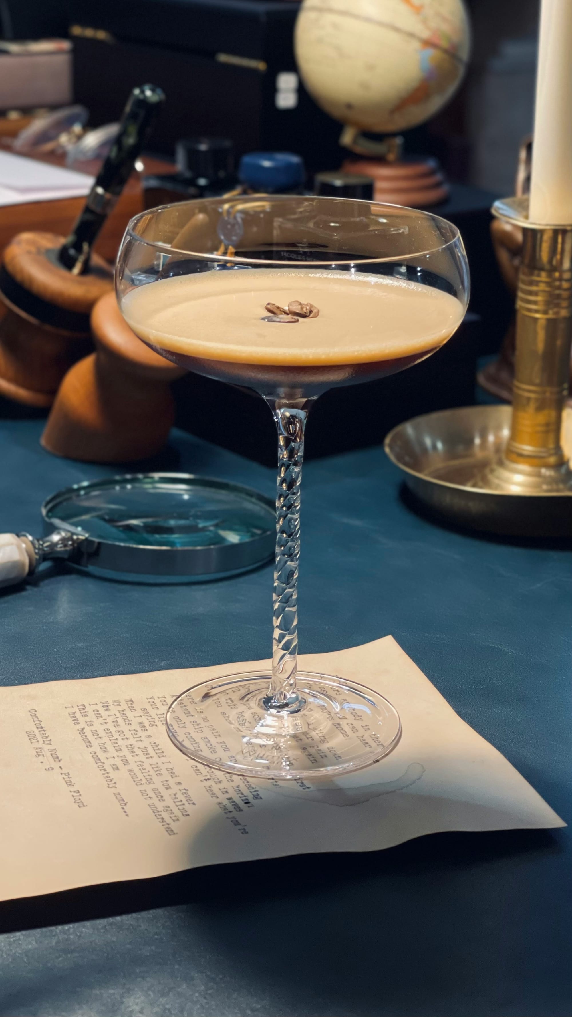 Närbild på en nygjord Espresso Martini med gyllene skum och isigt glas på marmorbord