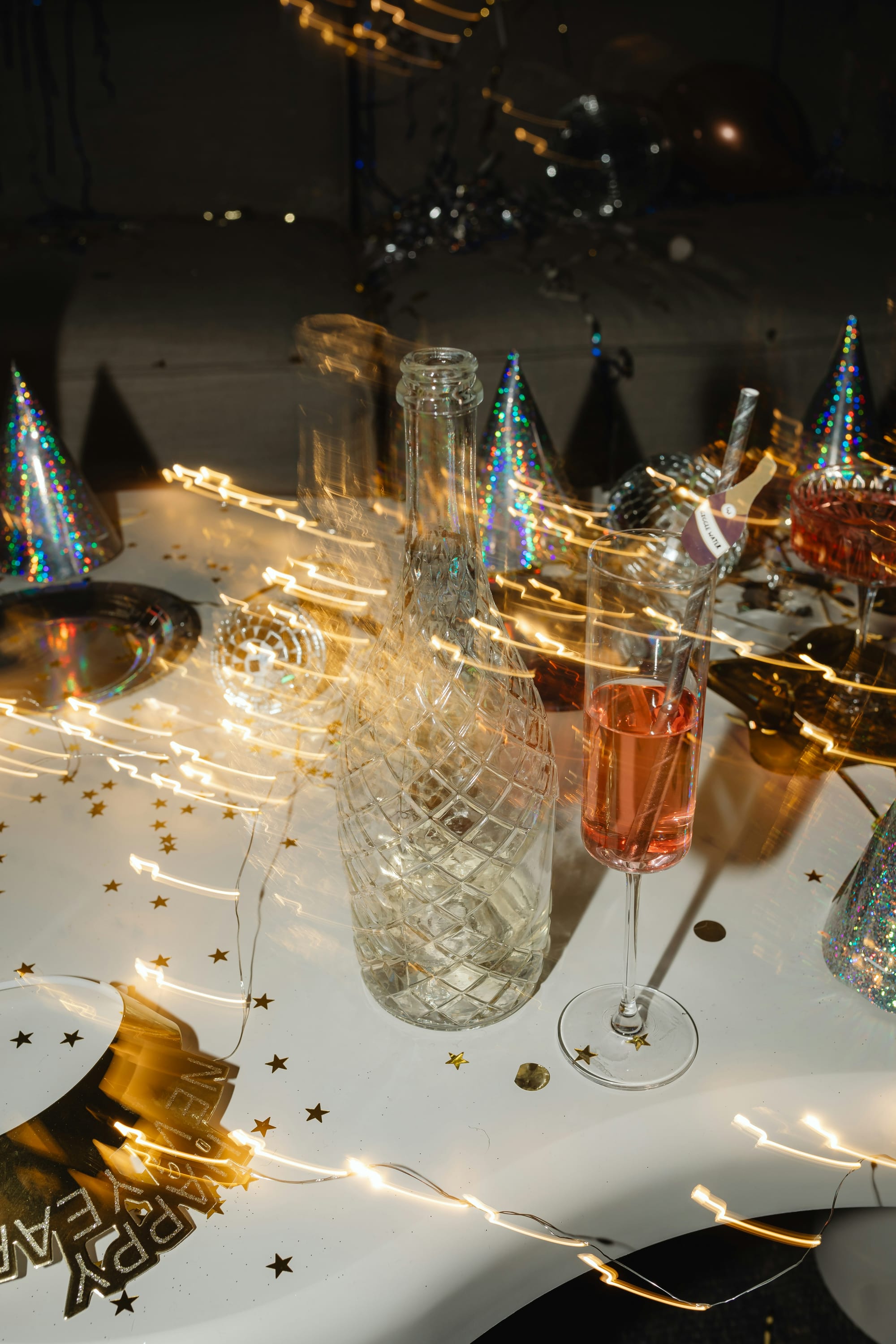 Festligt studentbord med champagneglas, flaskor och glittrande dekorationer – perfekta studentfest tips för en lyckad kväll.