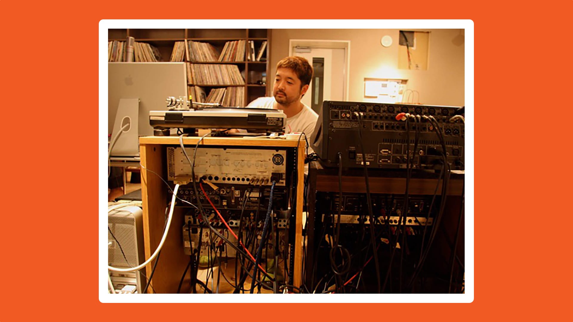 Image of Nujabes in his studio on an orange background.