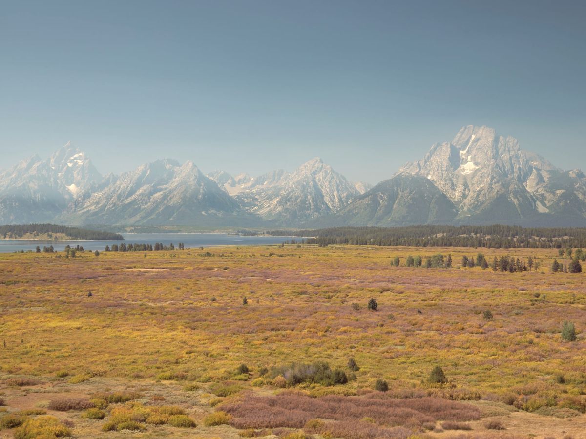 The Teton Range rising above Jackson Lake and the autumn valley floor, seen from Lunch Tree Hill in Grand Teton National Park.