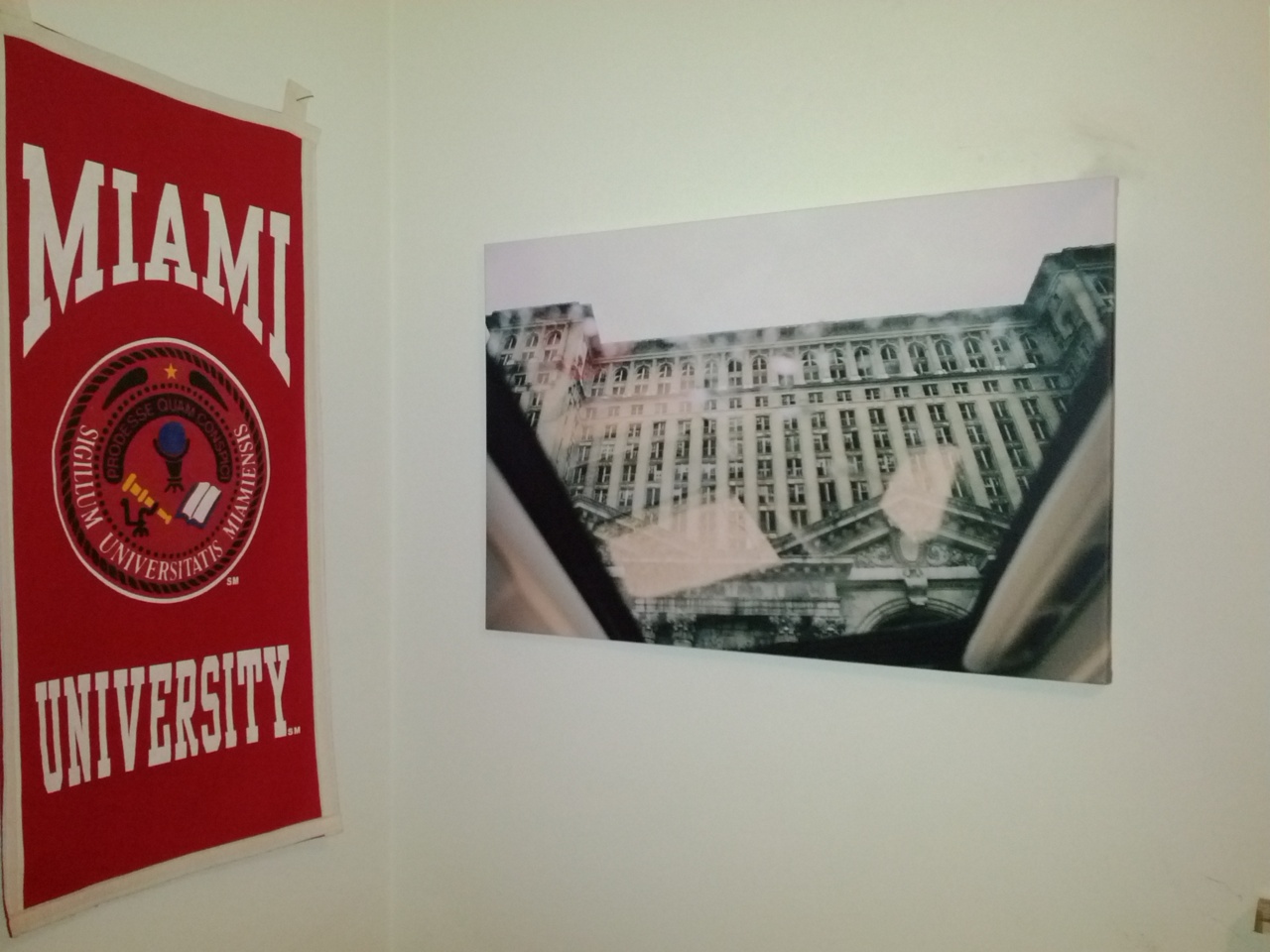 Canvas print of Michigan Central Station mounted on a white wall beside a red Miami University banner.