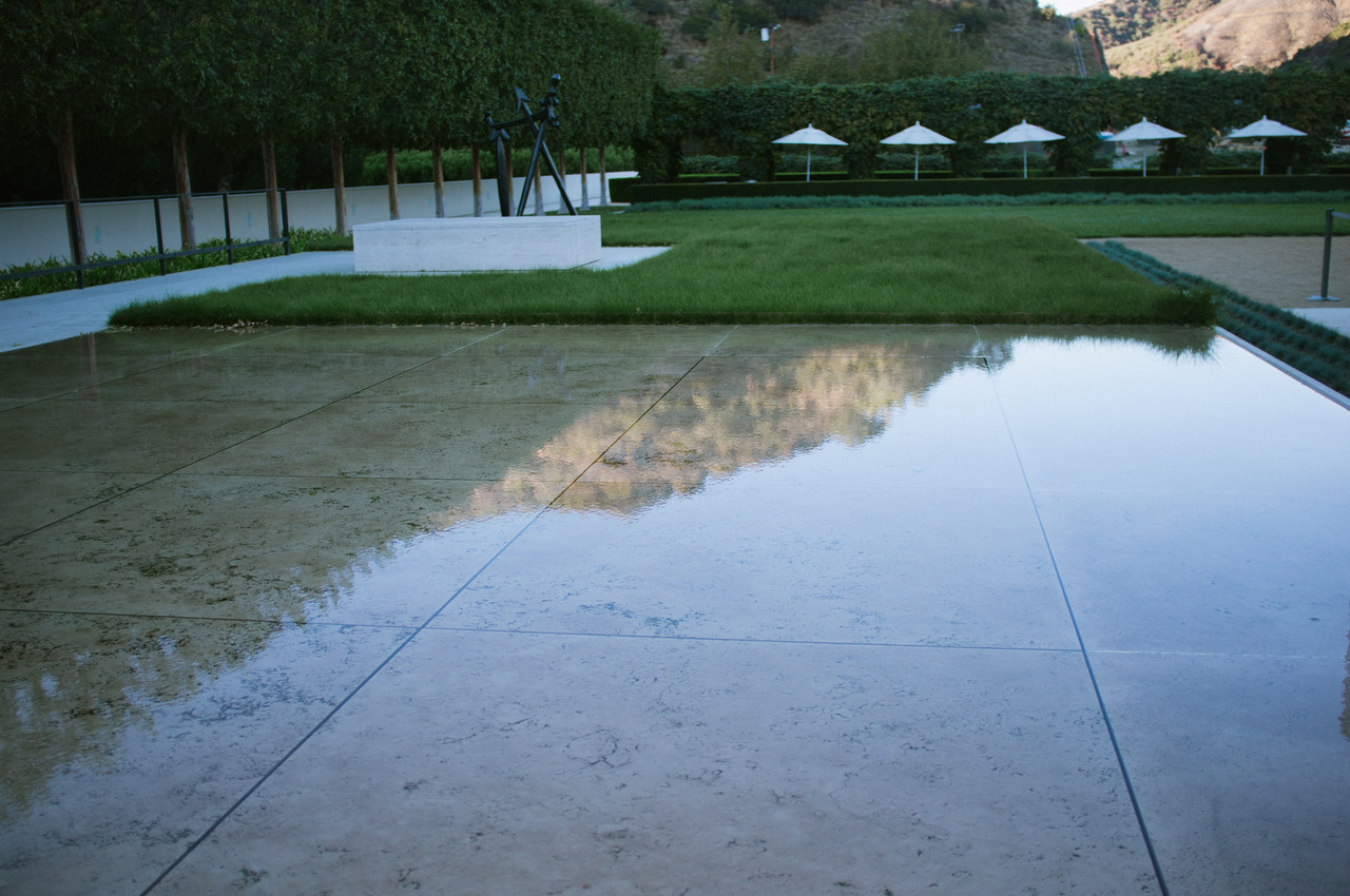 Still water reflecting pool courtyard at the Getty Center mirroring the surrounding hillside and sky, captured with a Fujifilm FinePix X100.