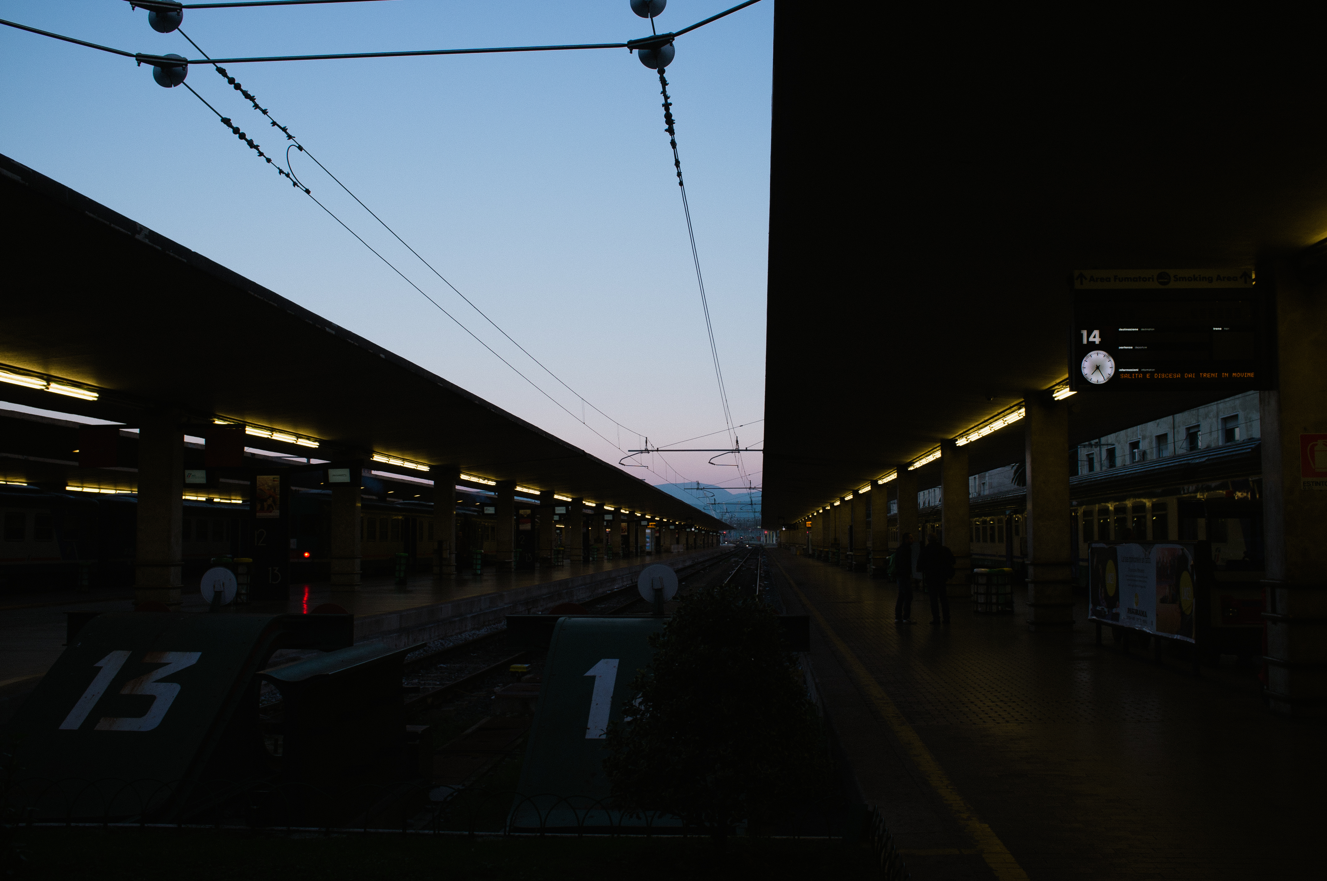 Dusk view down the railway tracks between passenger platforms at the Florence train station.