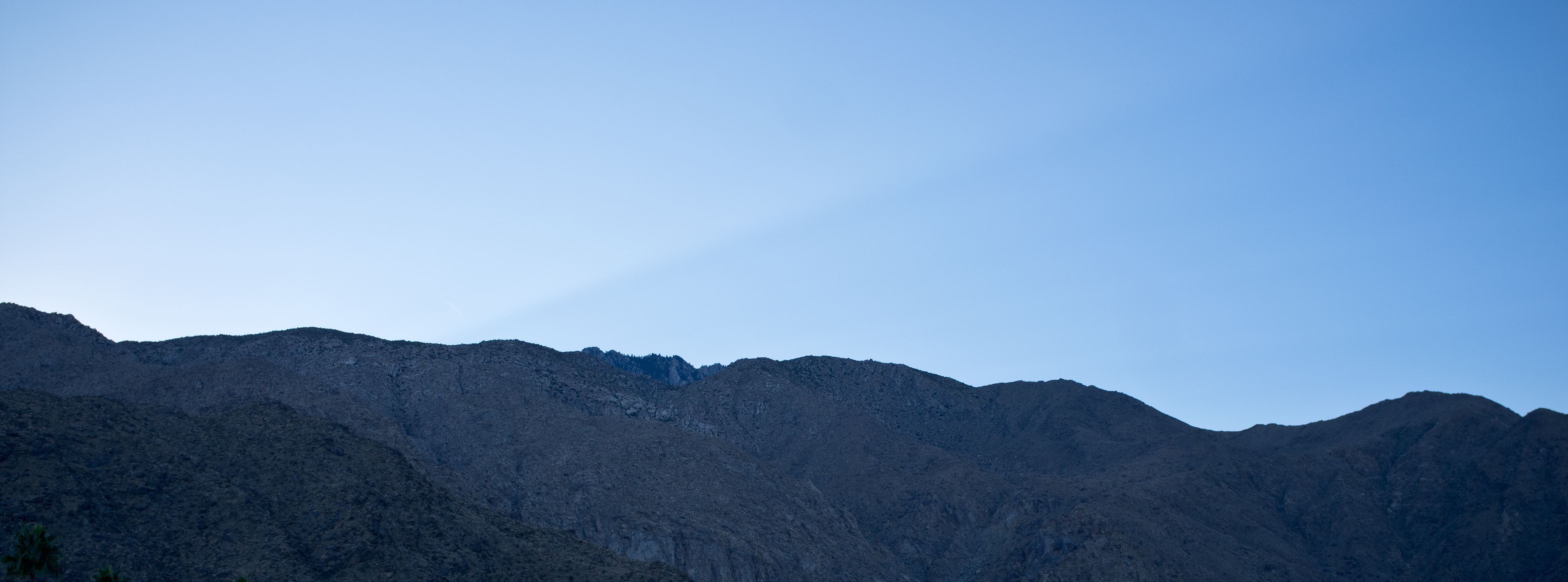 San Jacinto mountain ridges silhouetted against a clear gradient twilight sky in Palm Springs.