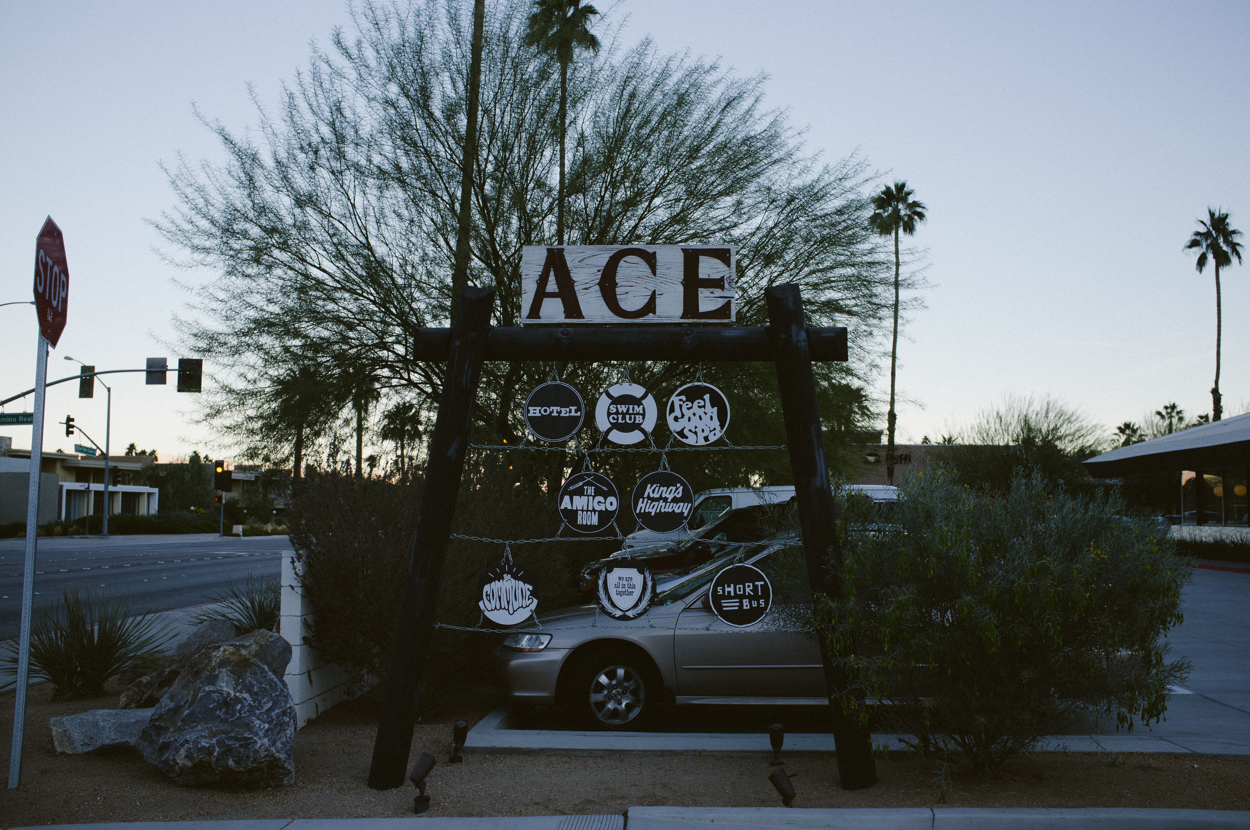 Ace Hotel signpost in Palm Springs pointing to Swim Club, Feel Good Spa, and King's Highway.