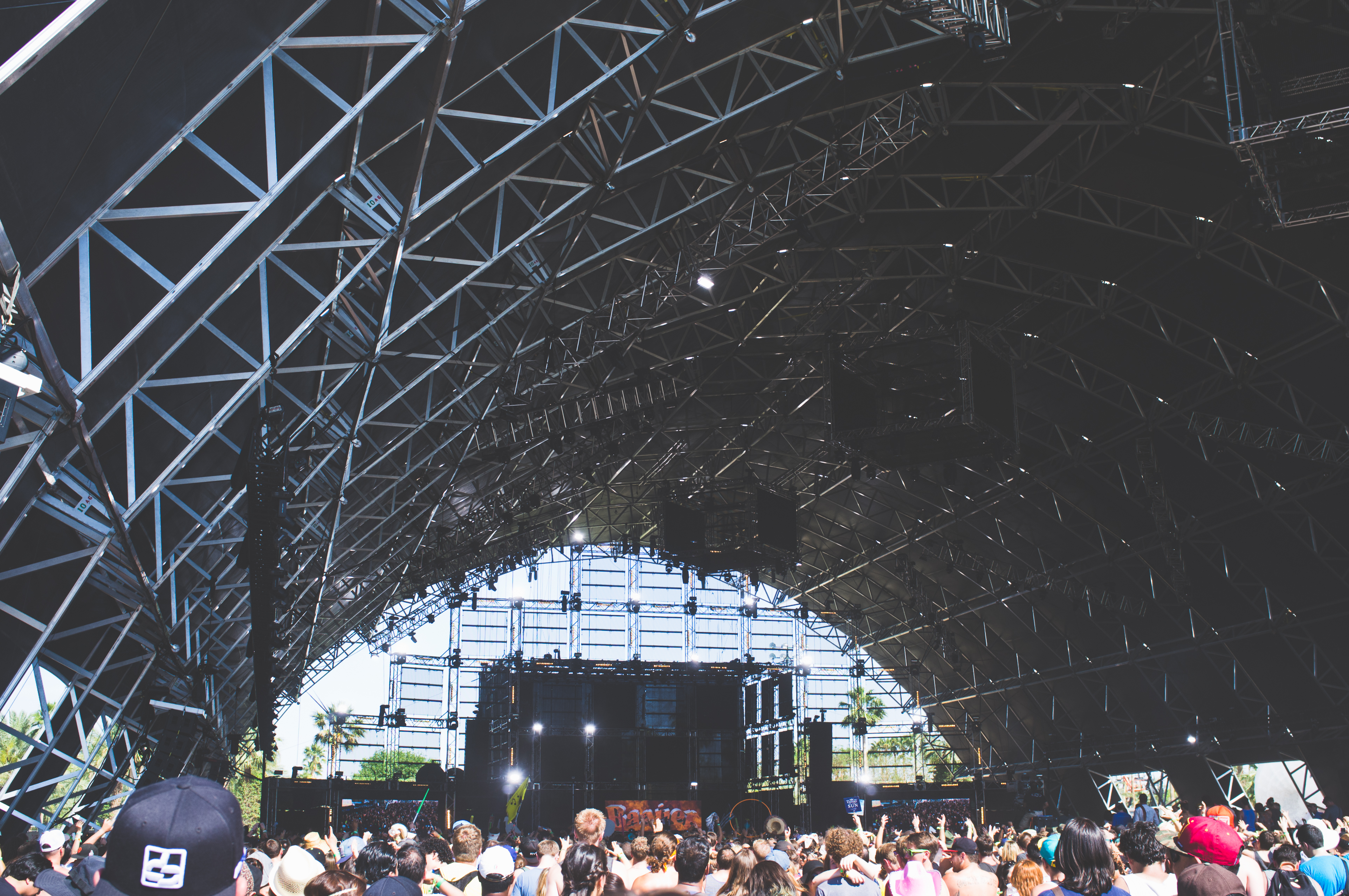 Dancing festival crowd inside the arched steel truss Sahara tent at Coachella.