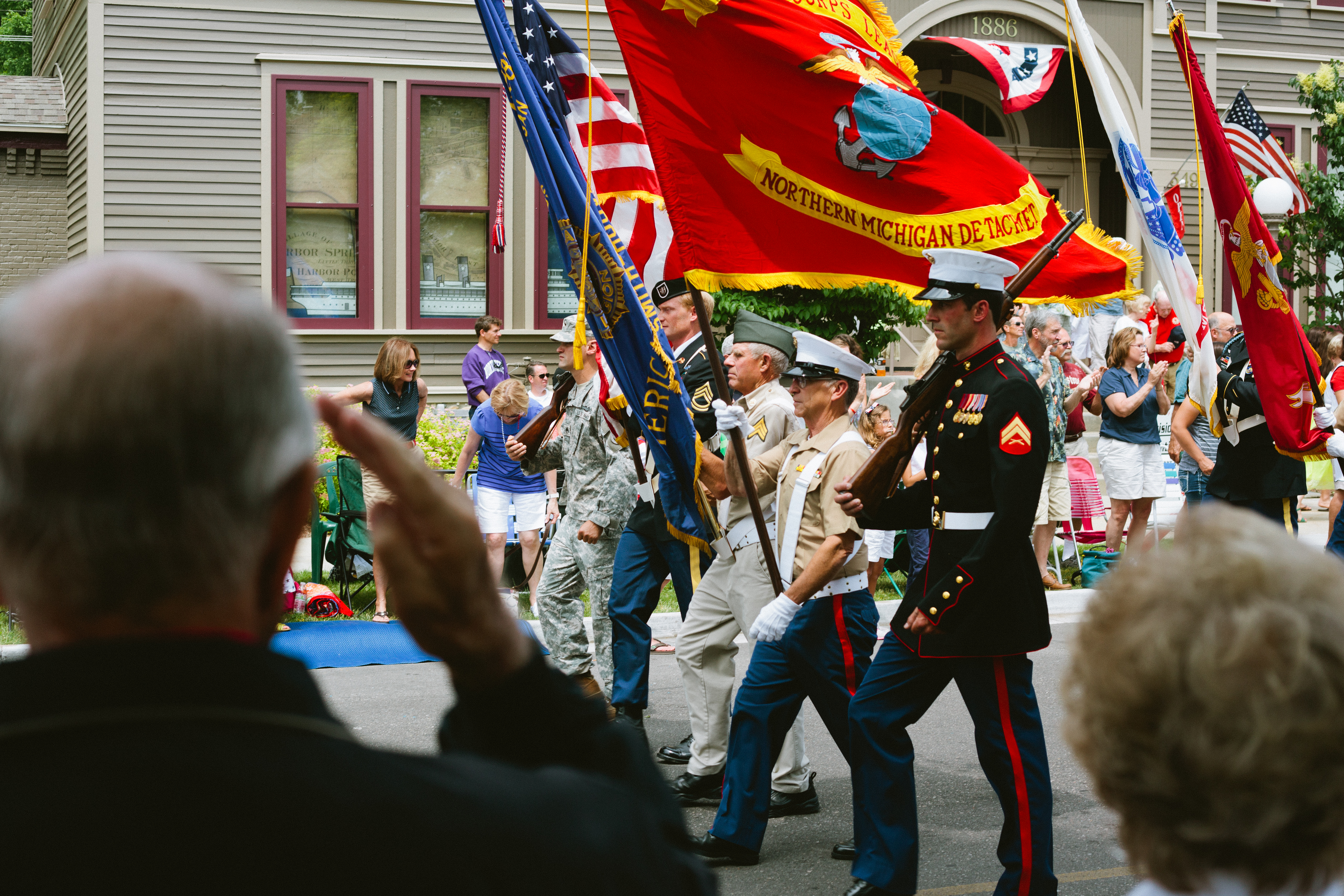 Color guard carrying American and Marine Corps flags in a Fourth of July parade in Harbor Springs.
