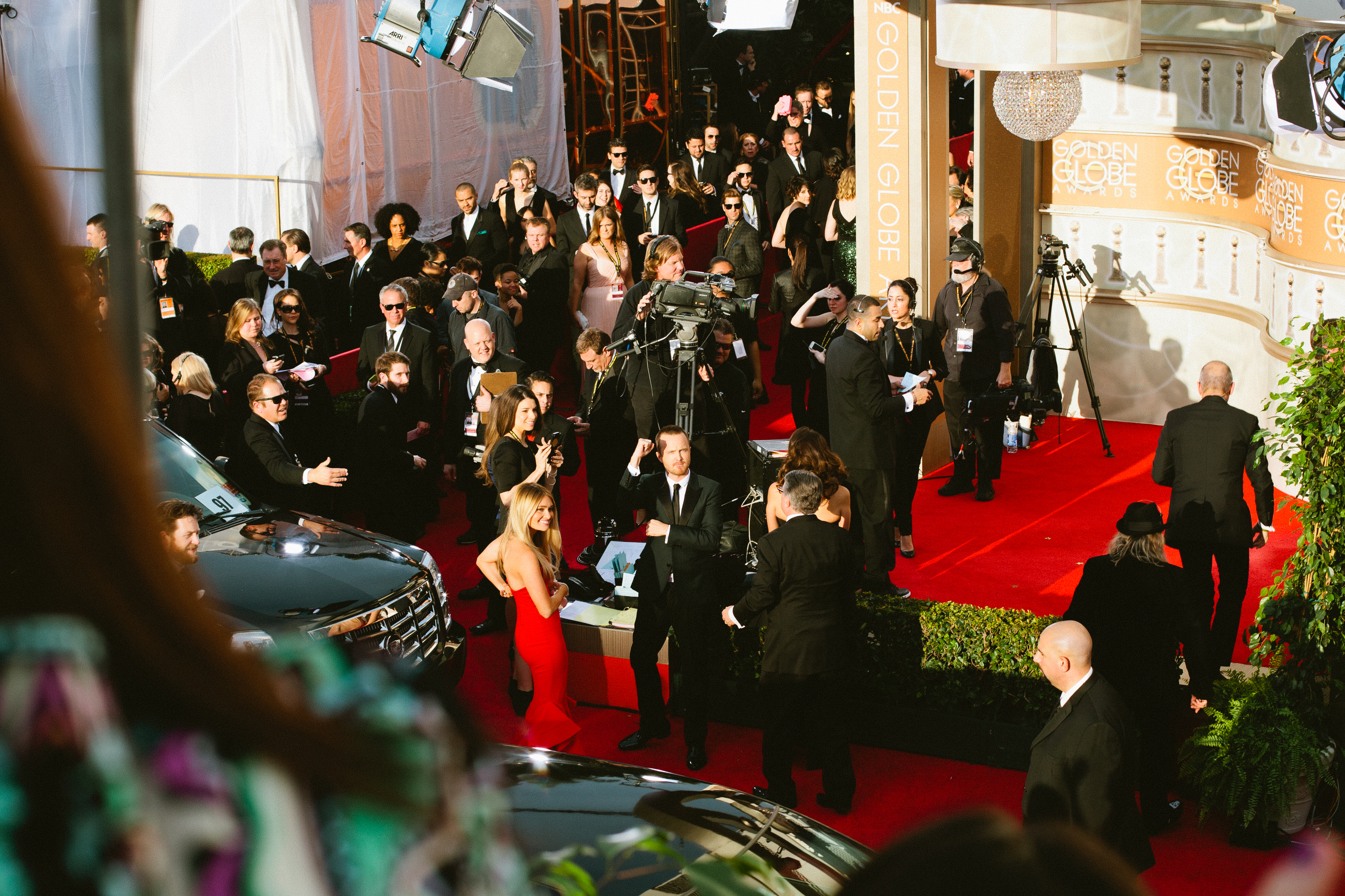Aaron Paul fist-pumping beside wife Lauren Parsekian on the Golden Globe Awards red carpet.