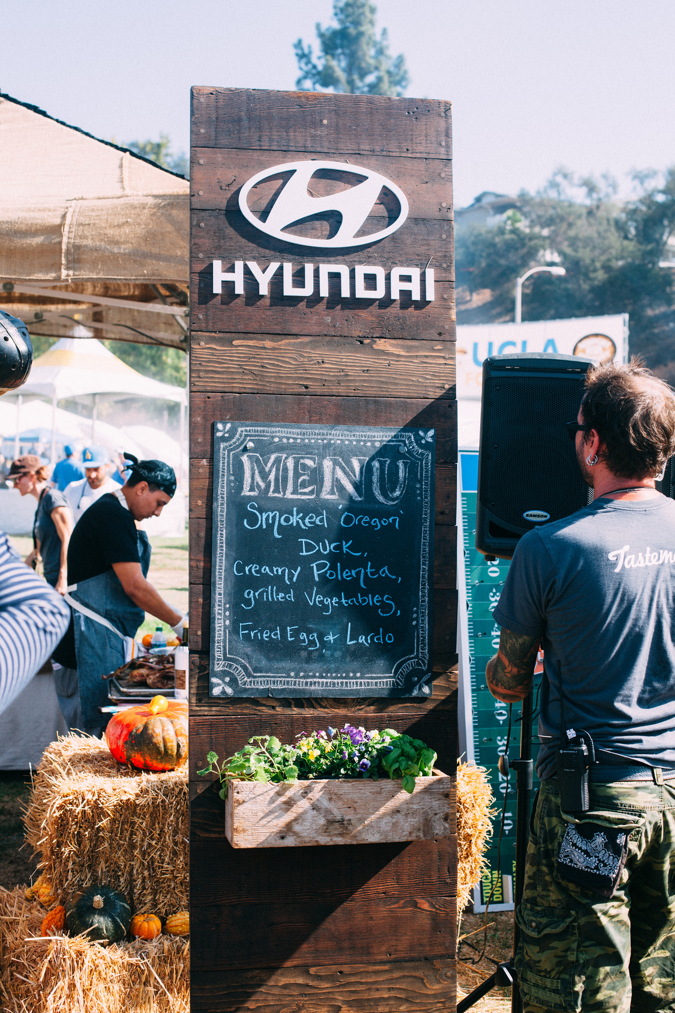 Tailgate chalkboard menu listing smoked Oregon duck, creamy polenta, grilled vegetables, and fried egg.