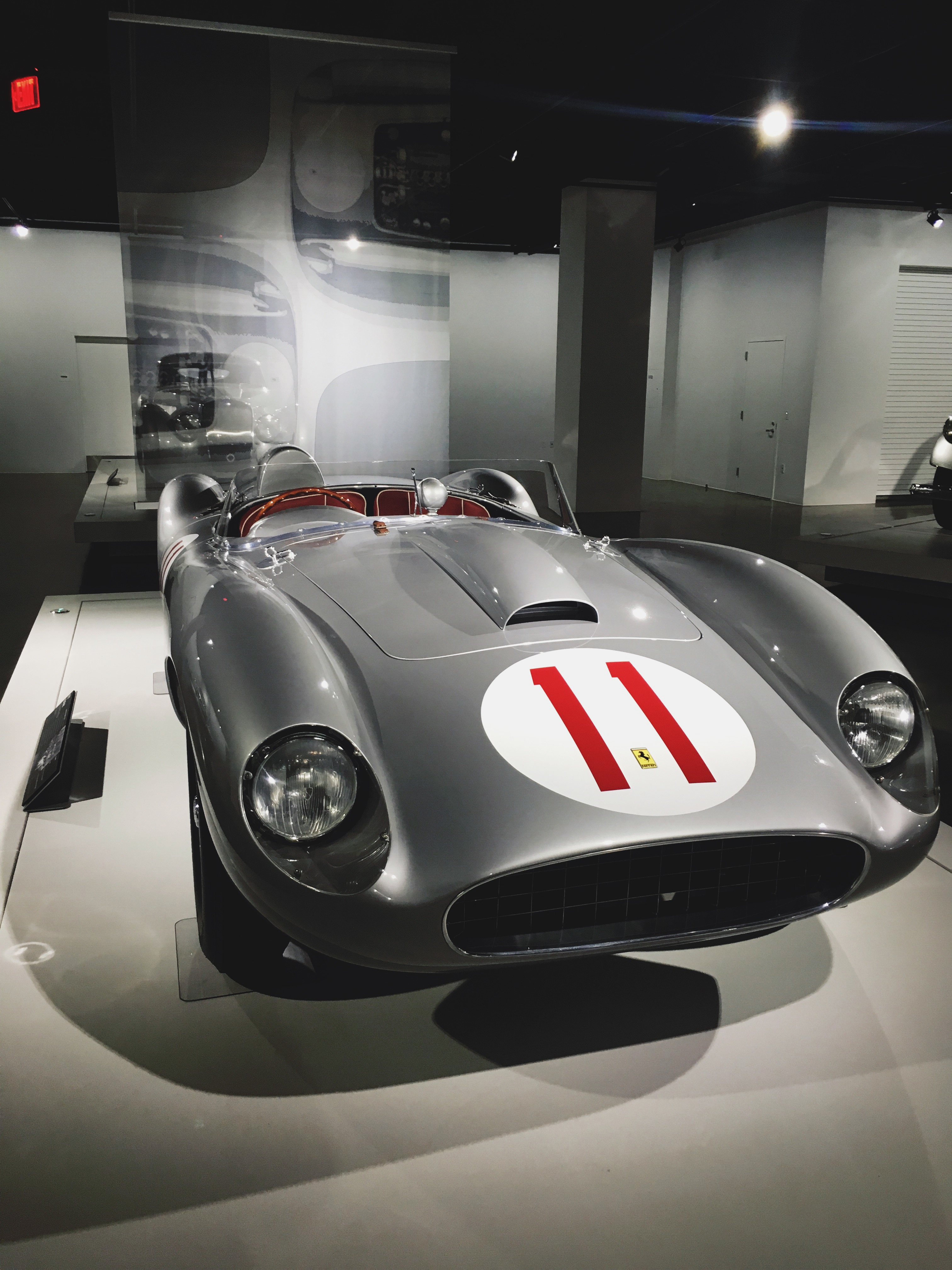 Classic silver open-cockpit Ferrari racing car bearing number 11 at the Petersen Automotive Museum.