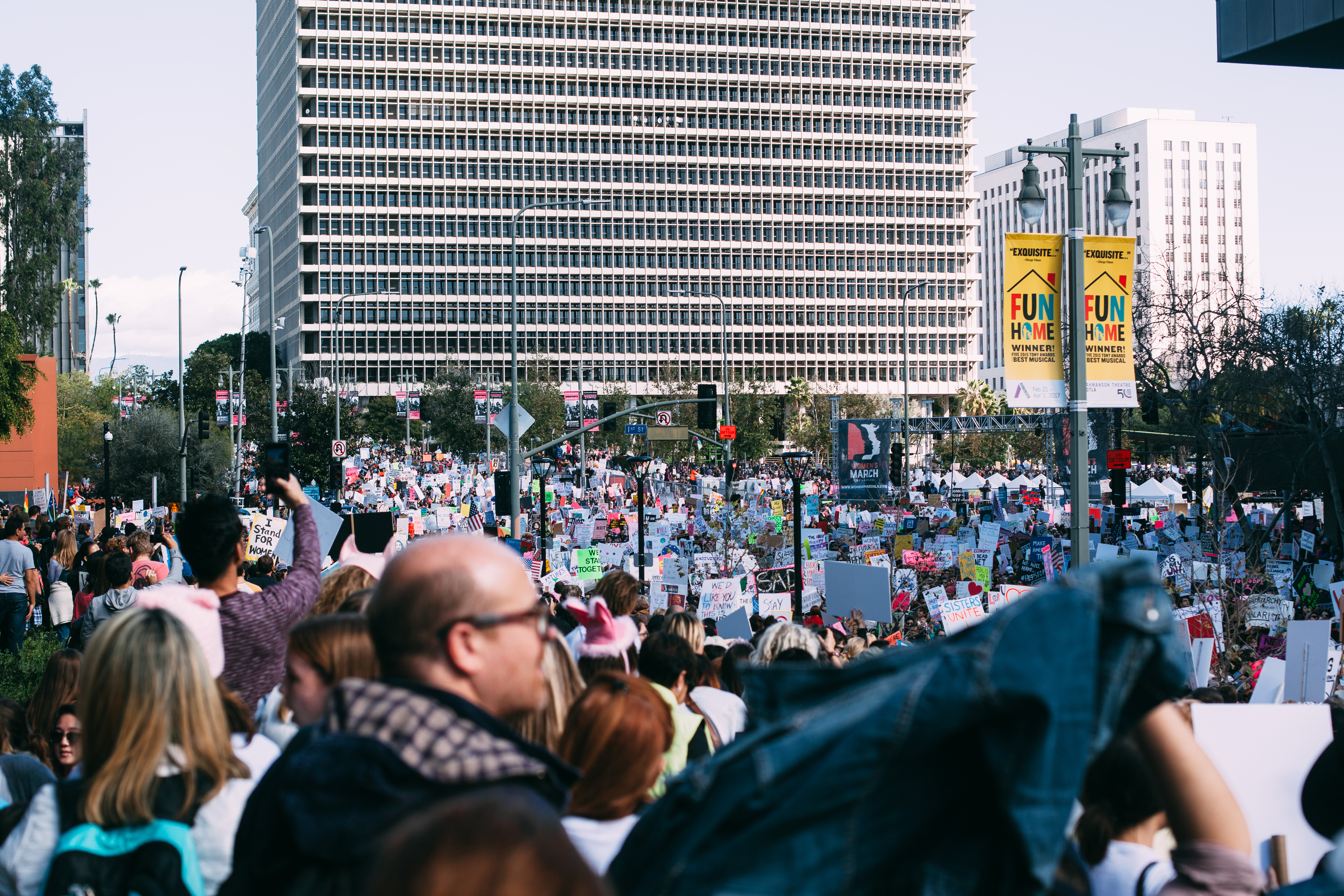 A massive crowd of thousands of demonstrators holding signs filling Grand Park in front of the Los Angeles County Hall of Administration during the Women's March, shot with a Canon 5D Mark II.