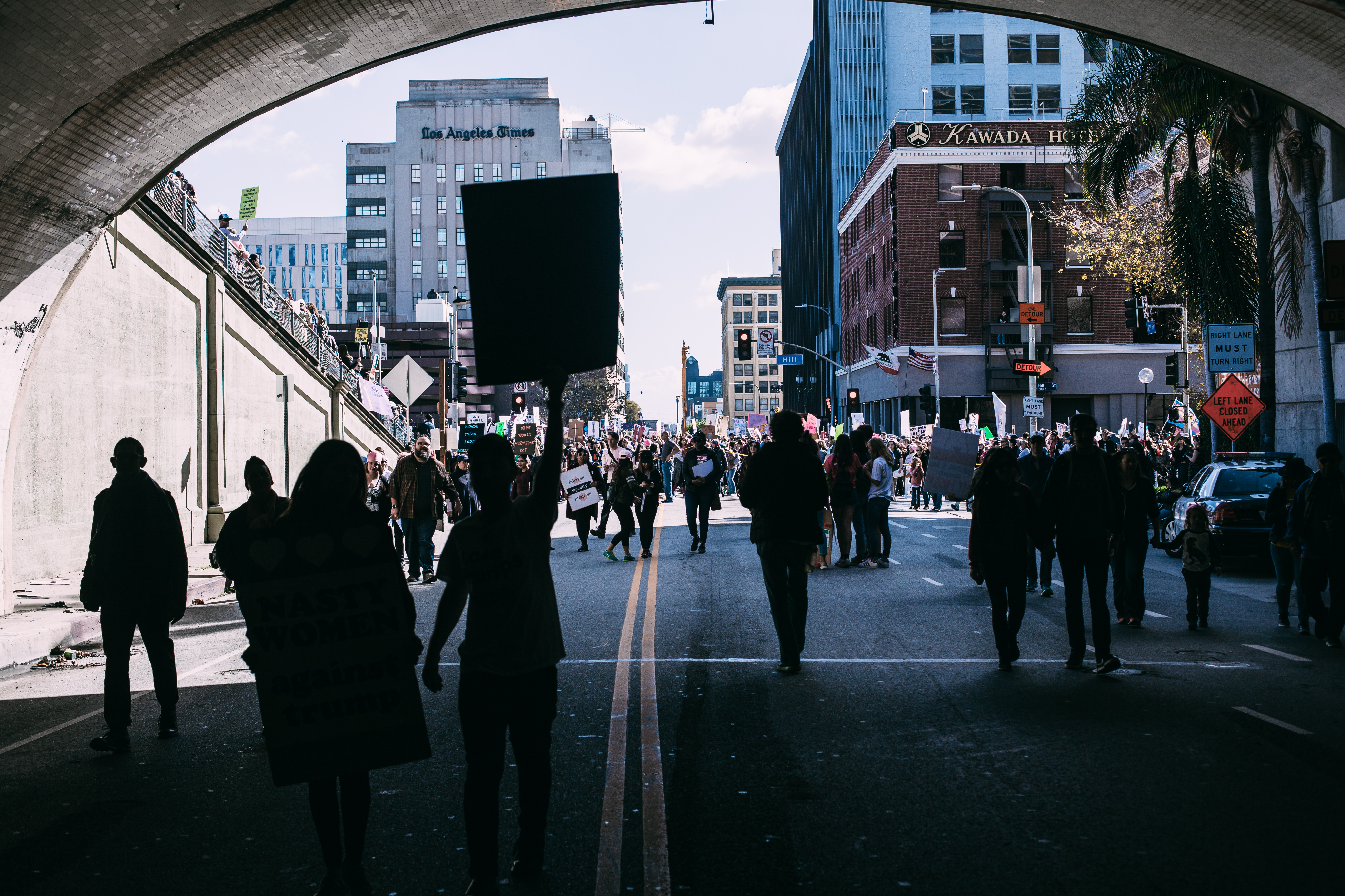 Silhouettes of protesters marching through the 2nd Street Tunnel toward Hill Street with the Los Angeles Times building and Kawada Hotel in the background during the Women's March, shot with a Canon 5D Mark II.