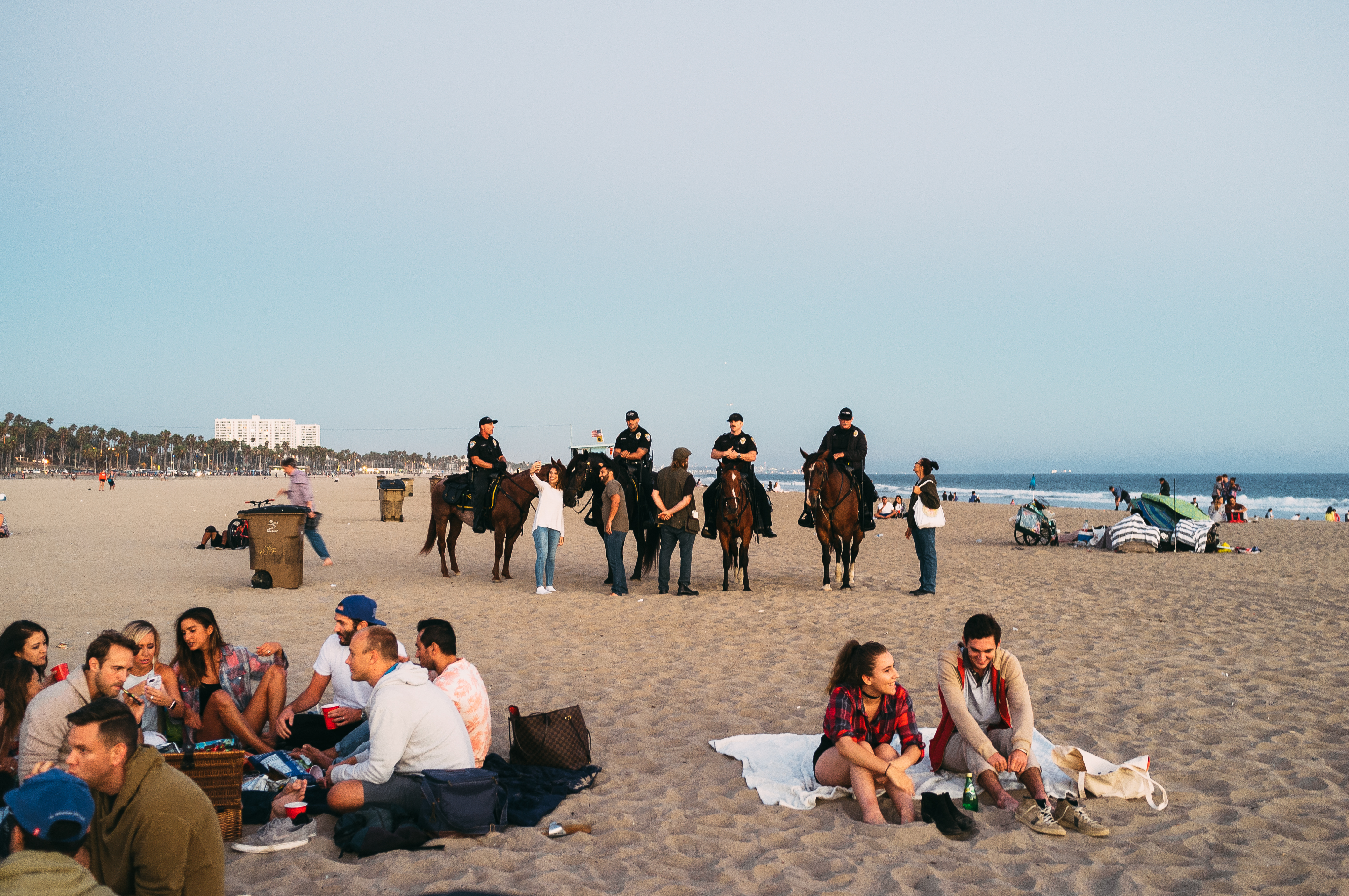 Crowd on blankets at sunset with mounted police on horseback during the Santa Monica Pier concert.