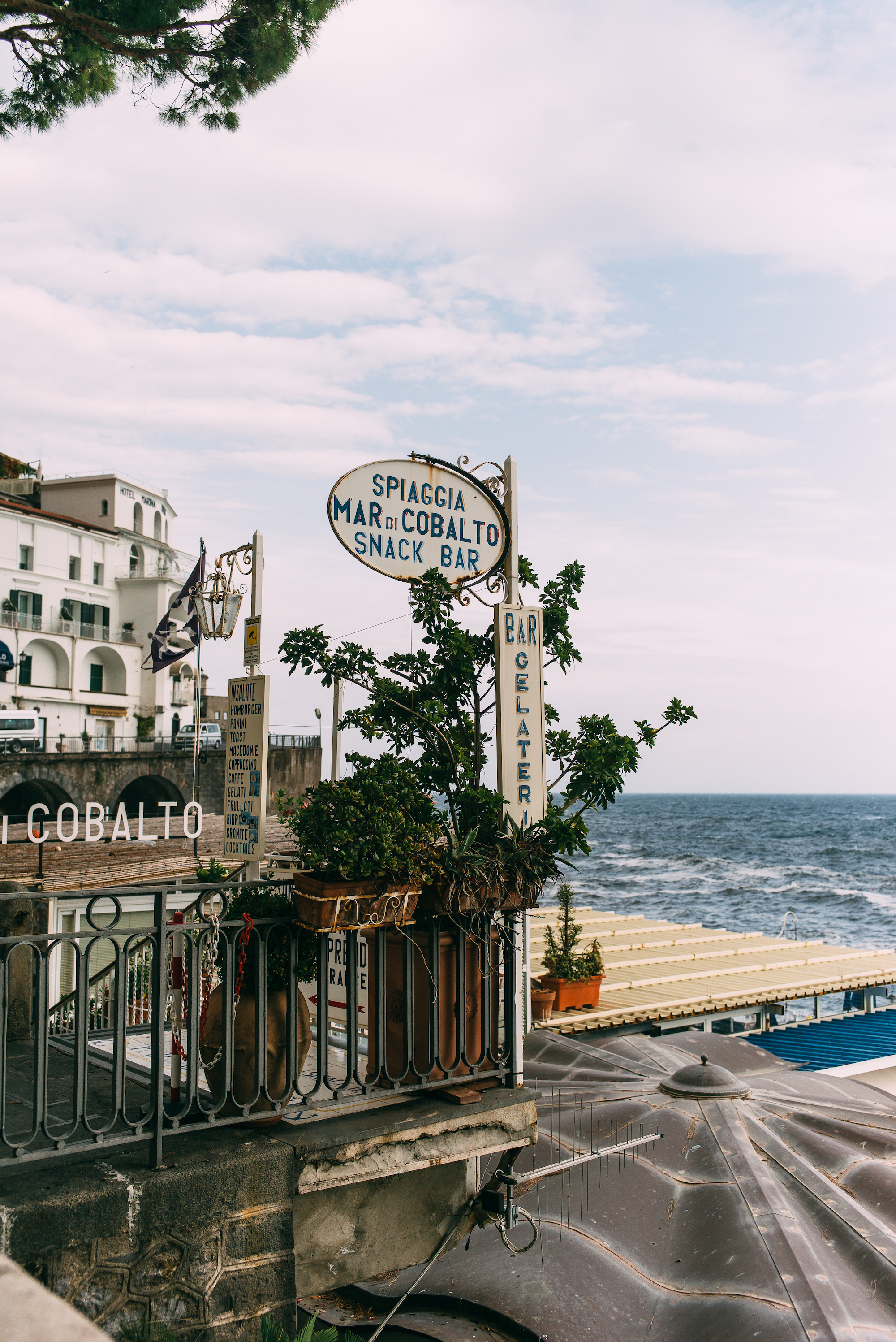 Coastal houses and church spires clinging to rugged mountainsides above the sea in Atrani on the Amalfi Coast.