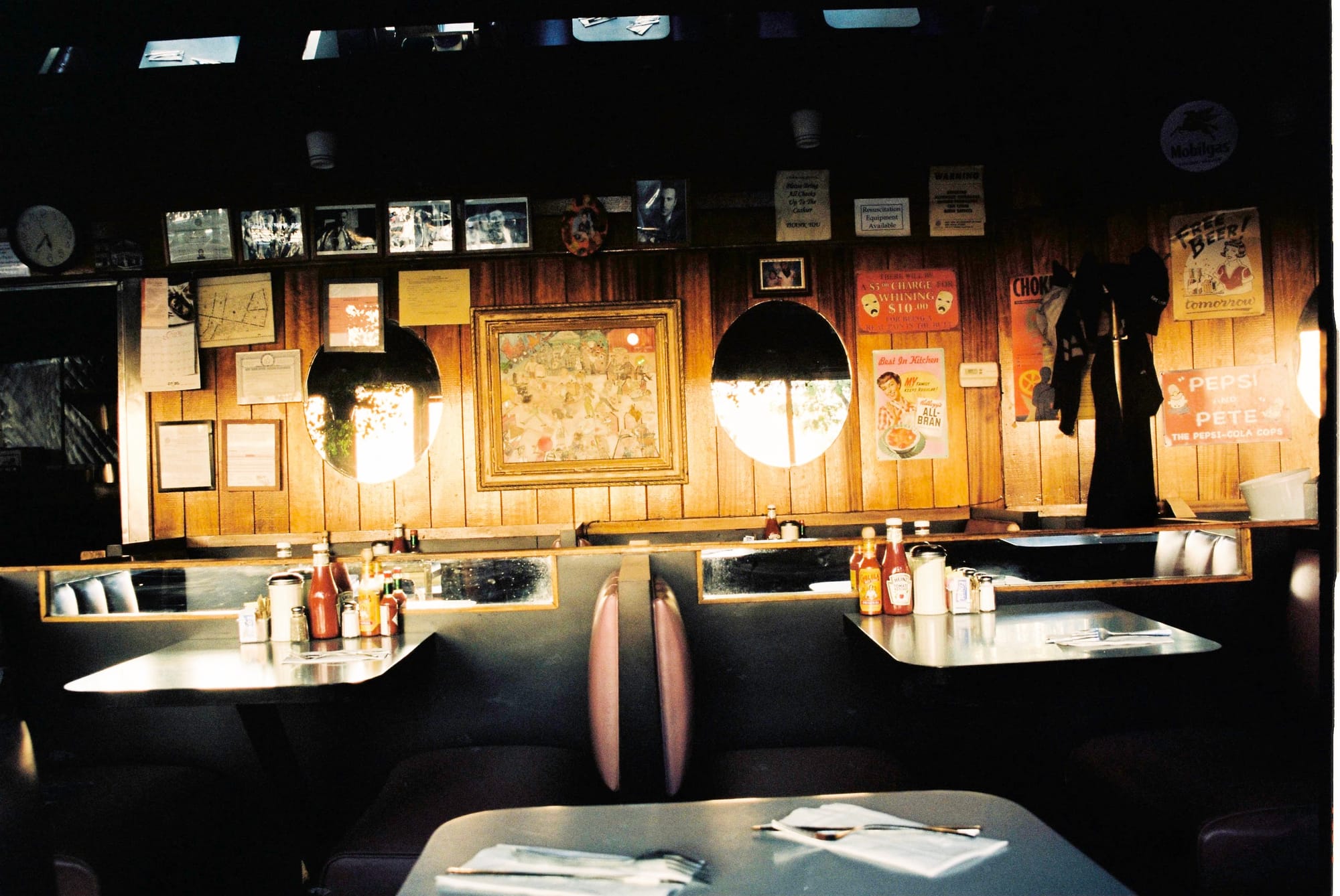 Warm interior of a classic New York City diner with wood-paneled walls, vintage signs, and dining booths.