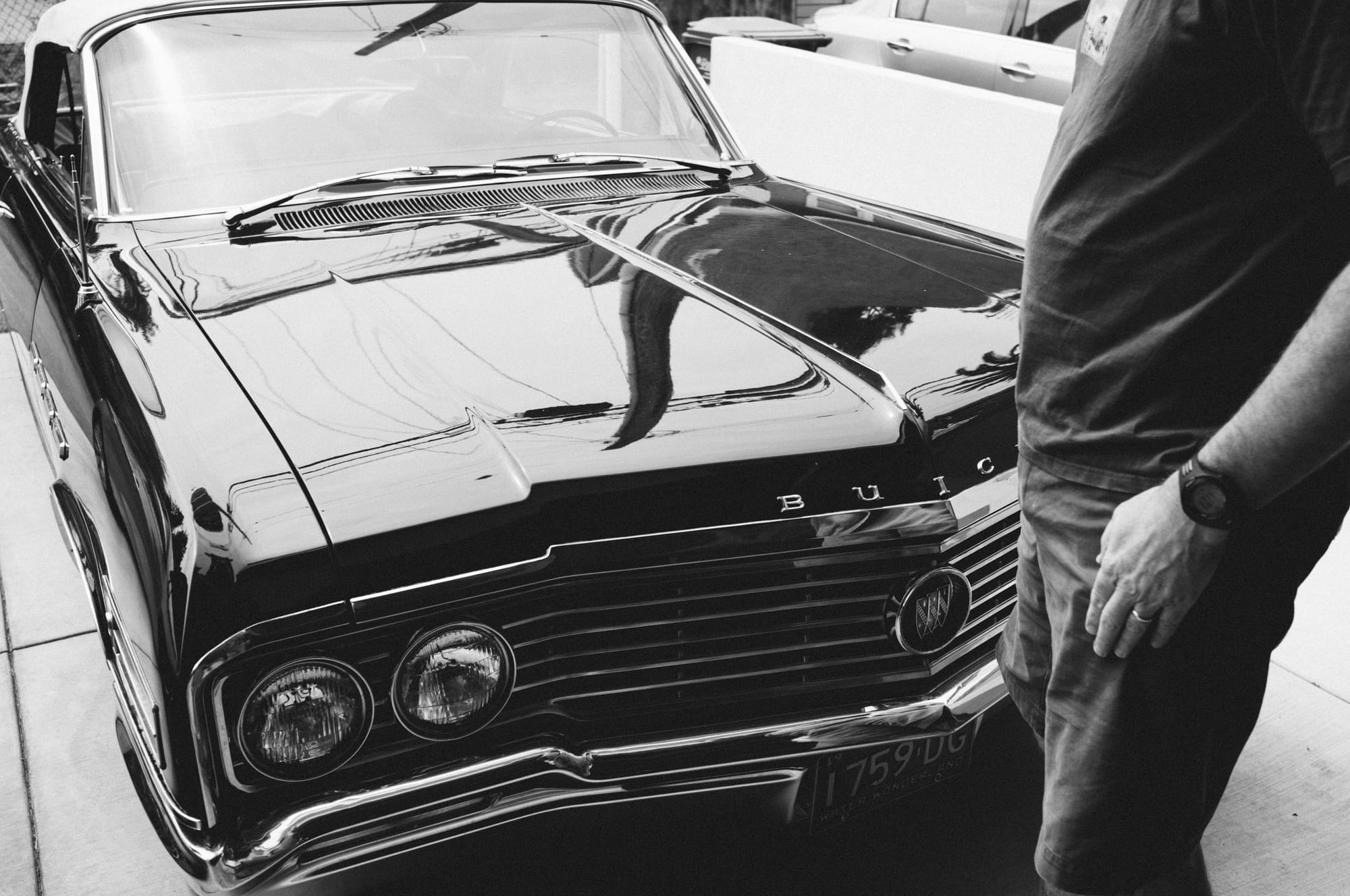 Close-up front angle of a classic black vintage car on a sunny street.