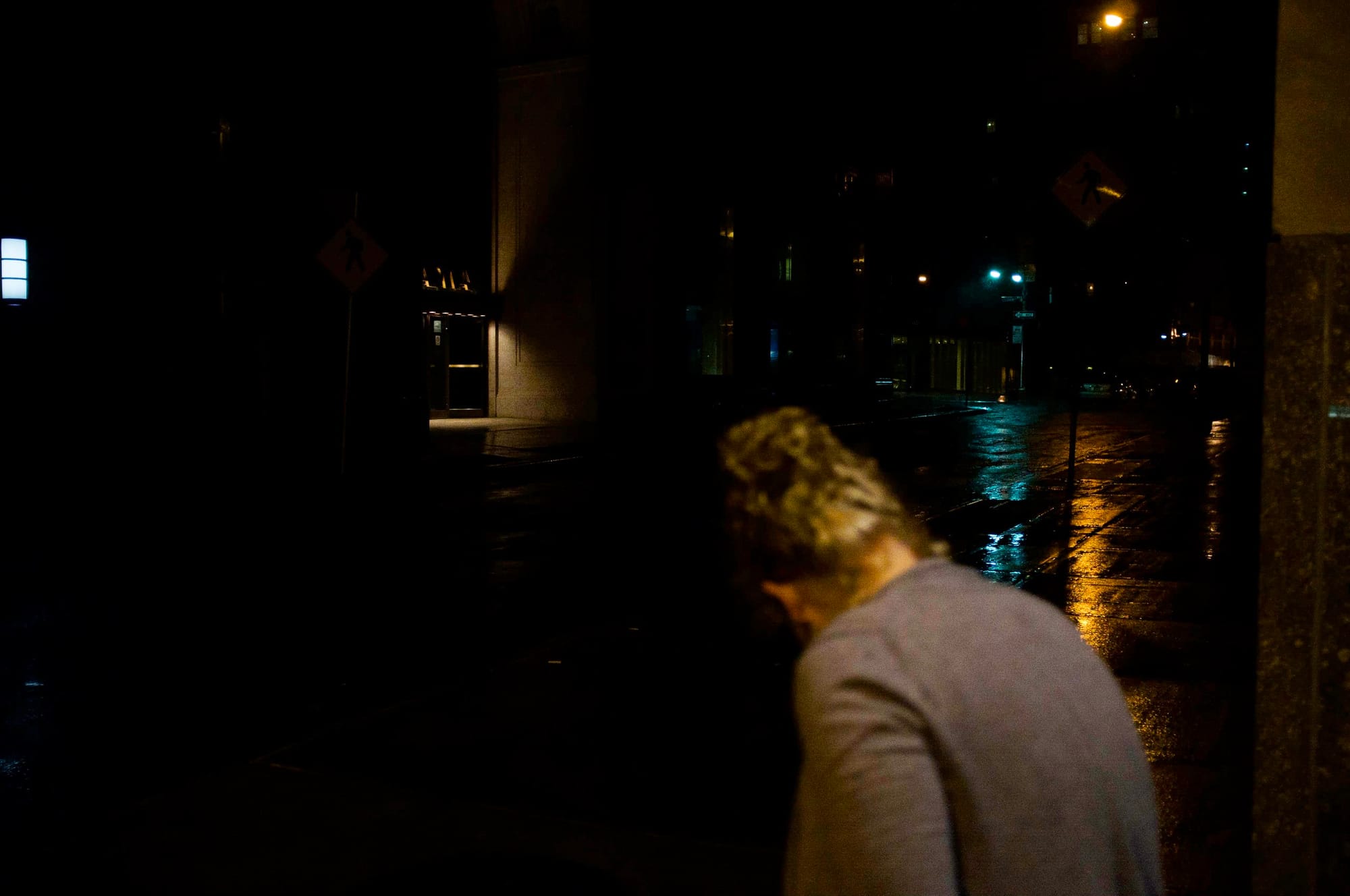 Deserted, rain-slicked city street in Lower Manhattan reflecting streetlights during Hurricane Irene.