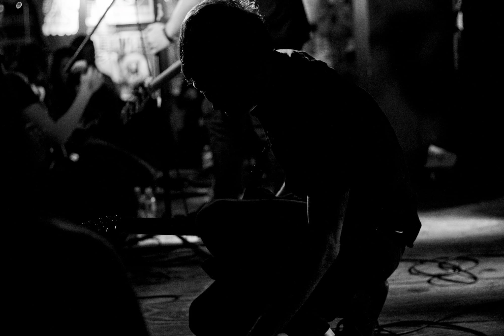 Lead singer gripping a vintage chrome microphone stand while singing beside a guitarist on stage.