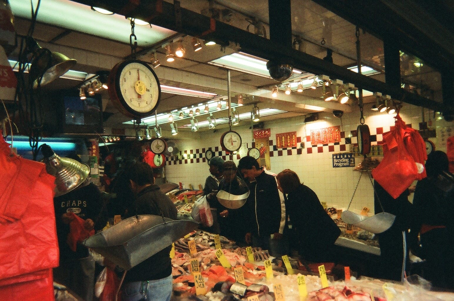Bustling open-air fish market stalls and vendor displays in Manhattan's Chinatown.
