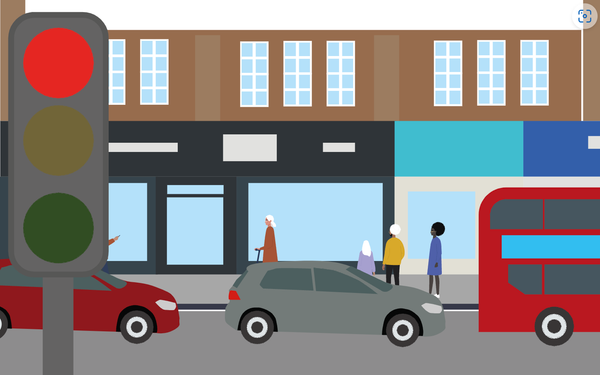 A high street with a traffic light on red.