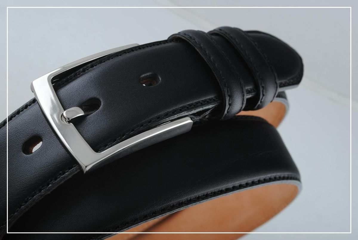 Detailaufnahme eines klassischen schwarzen Ledergürtels mit silberner Schnalle