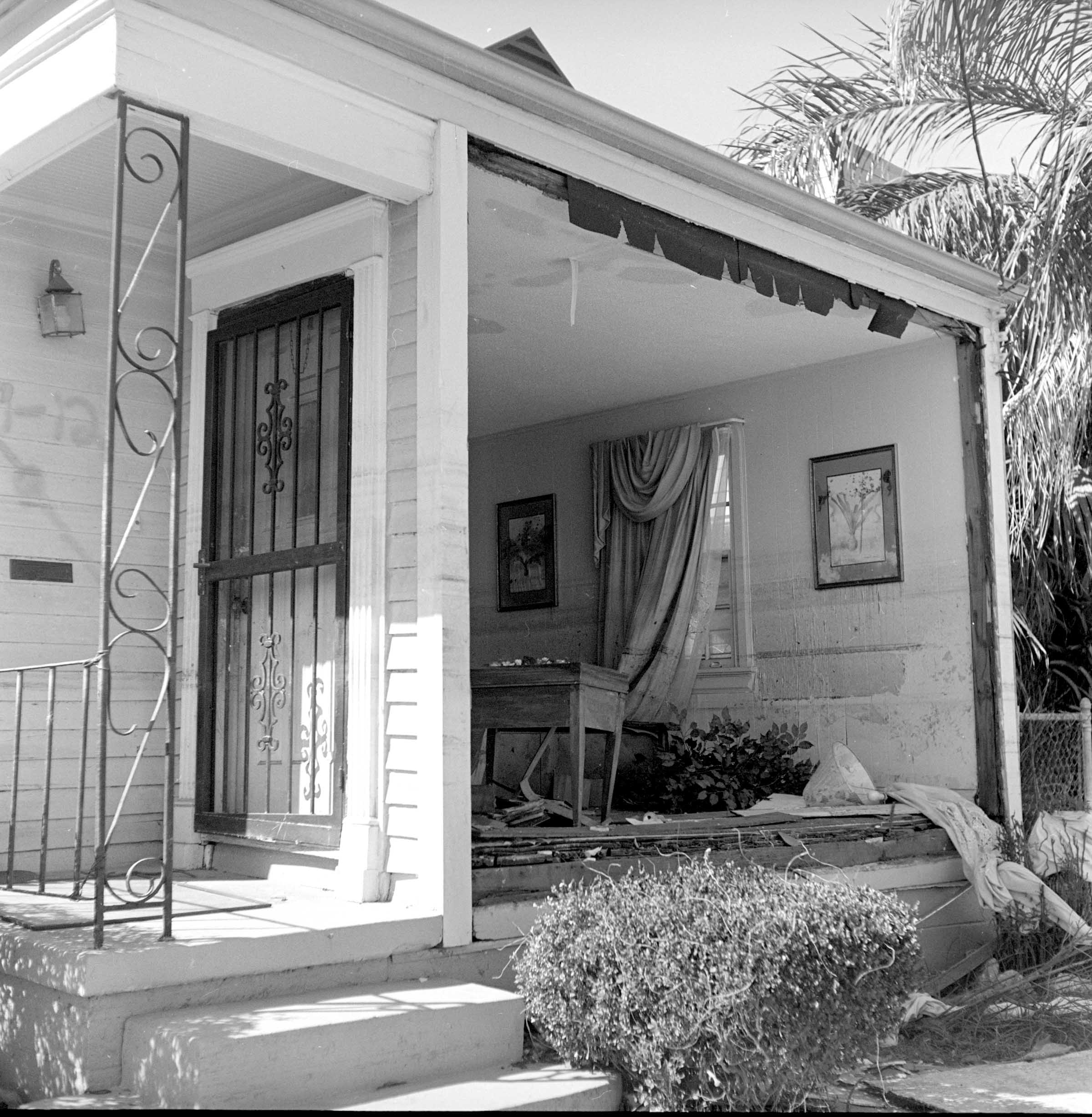 "Waterline #1." New Orleans, 2005. Inkjet Print on Canvas. Photographed in the Lower Ninth Ward after Hurricane Katrina, this image reveals a home torn open, one wall completely gone, exposing furniture and possessions still in place. The multiple waterlines etched across the interior mark how slowly the floodwaters receded, leaving behind both physical scars and a timeline of devastation. More than a portrait of destruction, this photograph documents the vulnerability of a community and the quiet endurance of lives interrupted yet unforgotten. Credit: Clarence Williams