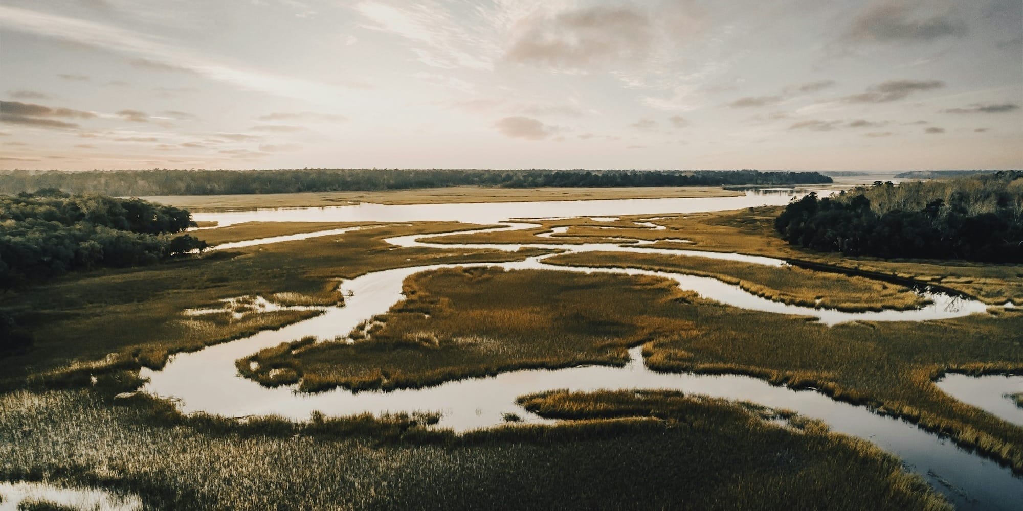 winding river across plains under downcast ssky