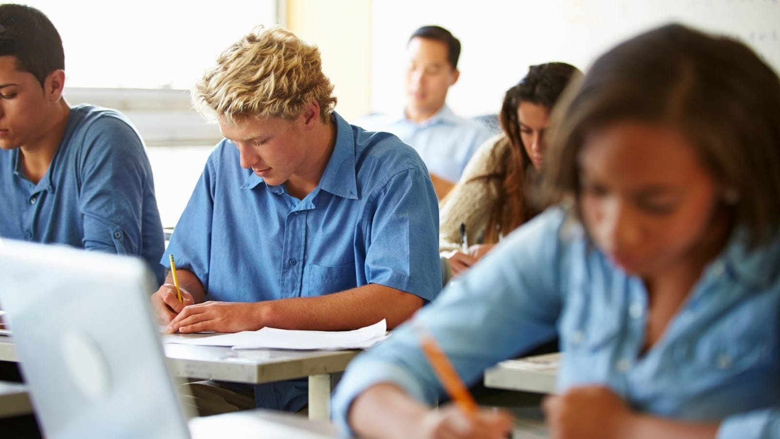Students attempting and an exam at school in the presence of an invigilator