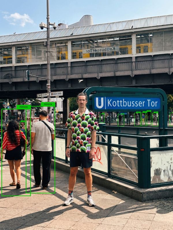 Simon Weckert 穿著 Digital Camouflage 襯衫站在 Kottbusser Tor，YOLO 標出周圍行人但沒有標記他
