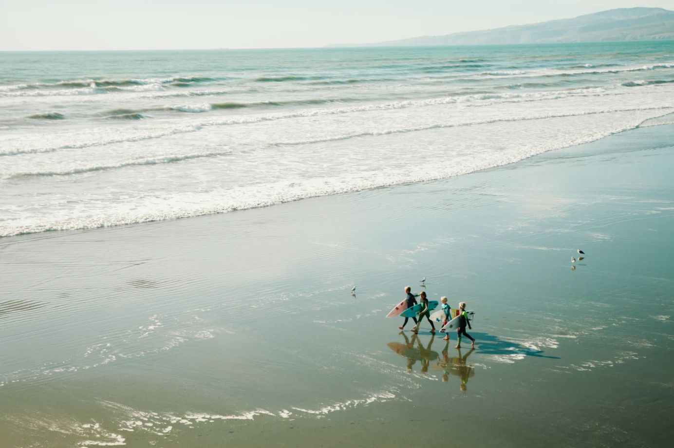 A group of kids on a family surf trip at the beach