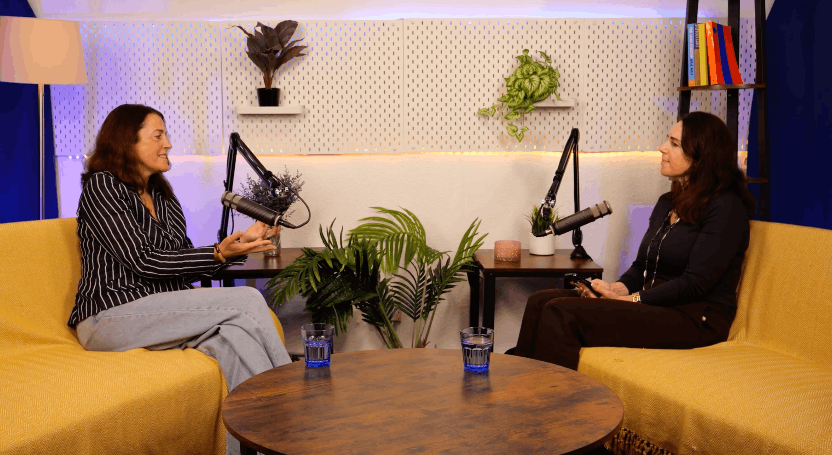 Jenny Tschiesche in a striped shirt and host Aleksandra King in conversation on the BEYOND set, seated on yellow sofas either side of a round wooden table