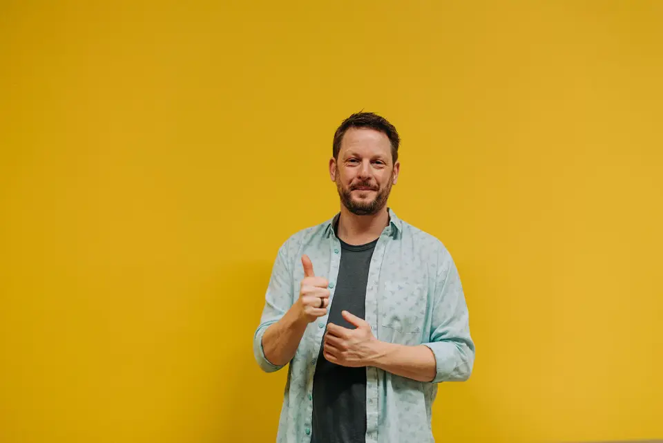 Mathew-matheson-Speaking-Coach.jpeg Mathew Matheson, the speaking coach, posed in front of a yellow background