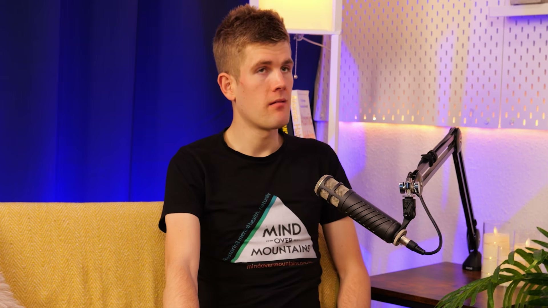 Alex Staniforth listening intently across the table on The BEYOND Podcast set