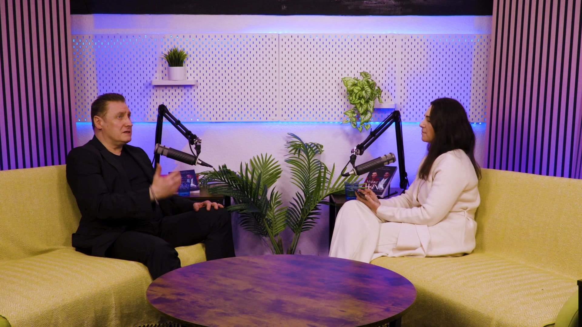 Grant Murrell gesturing as he talks to Aleksandra King across a round table on The BEYOND Podcast set