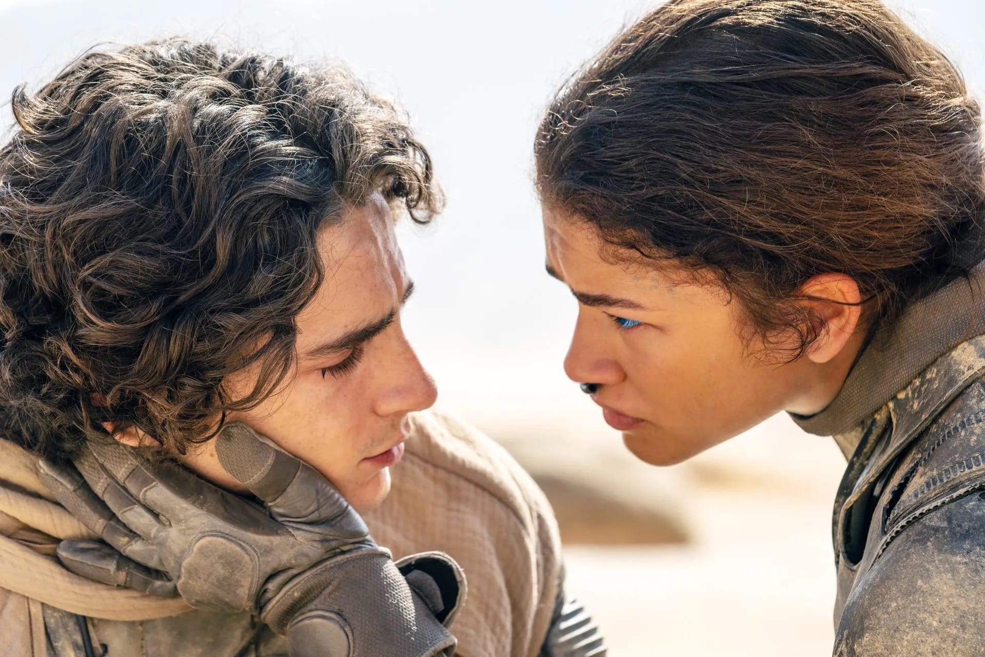 Dune Vol. 2: Chani holds her hand to Paul's cheek as they sit on top of a sand dune.