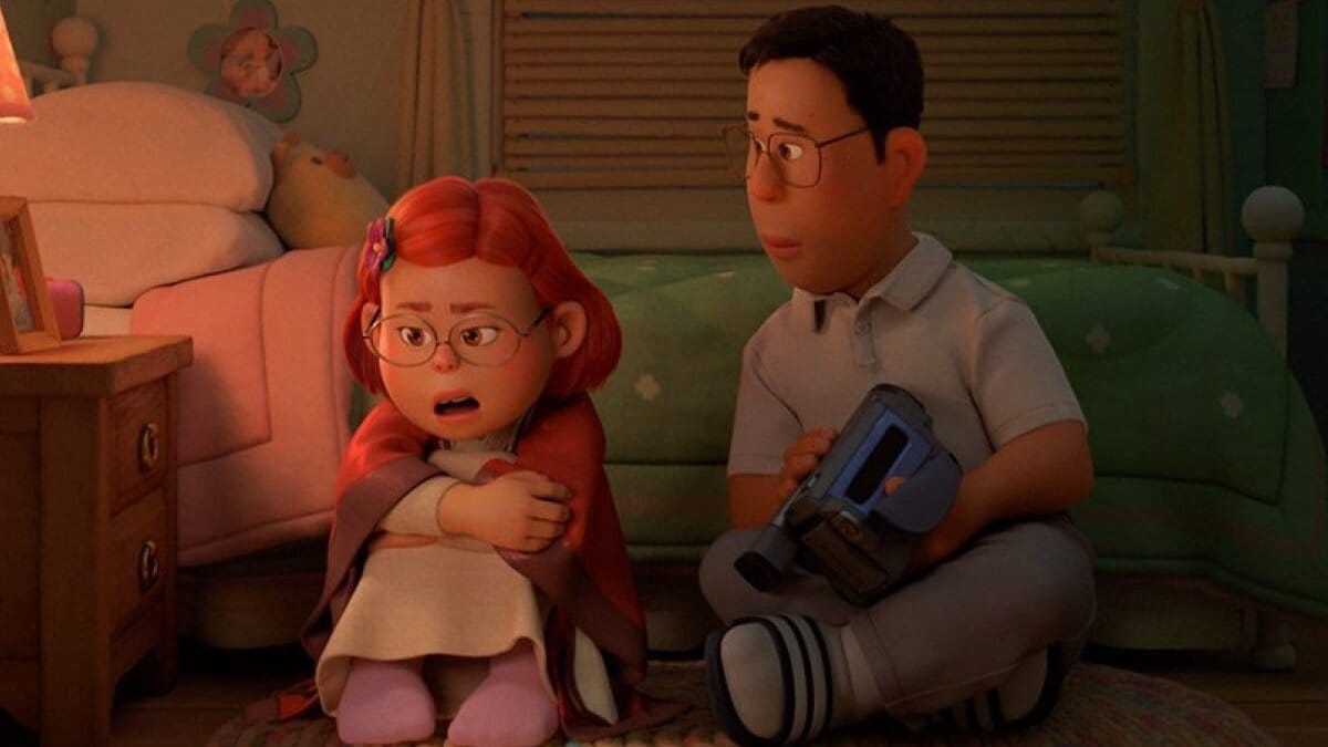 Mei and Jin from Turning Red sitting on the floor of Mei's bedroom. Jin listens to Mei while holding a video camera.