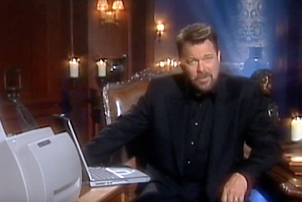 Jonathan Frakes sitting next to a laptop and printer on the set of that show where he asks you questions.
