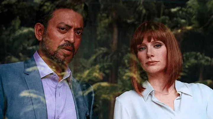 Jurassic World: Simon Masrani and Claire Dearing look into the Indominus Rex enclosure, reflected against their faces on the security glass.