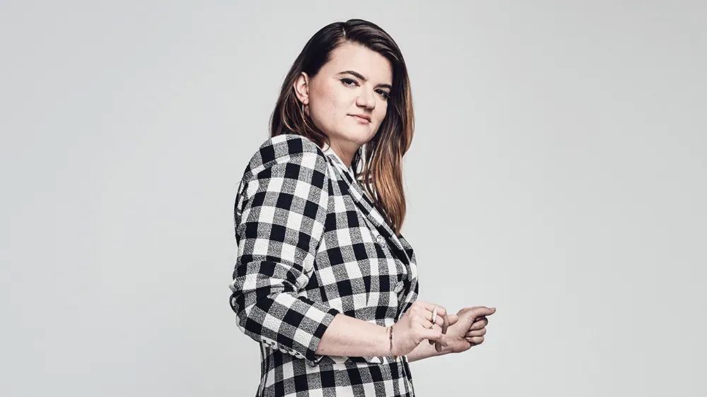 Leslye Headland stands in a black and whit checked blazer