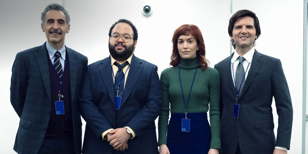 The Innies of Severance taking a group photo in the office with a security camera behind them.