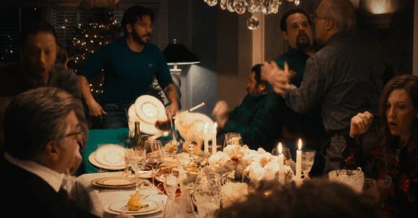A family scrambles around a dinner table in panic as two men fight, in a still from The Bear