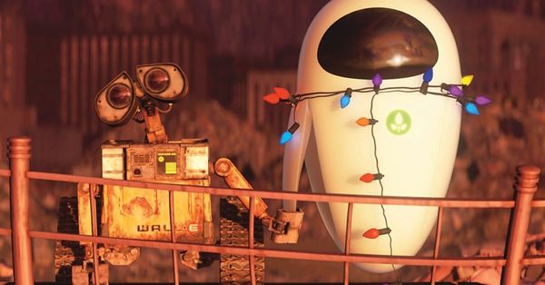 WALL-E and EVE hold hands while watching an explosion. EVE has Christmas lights wrapped around her like a lasso.