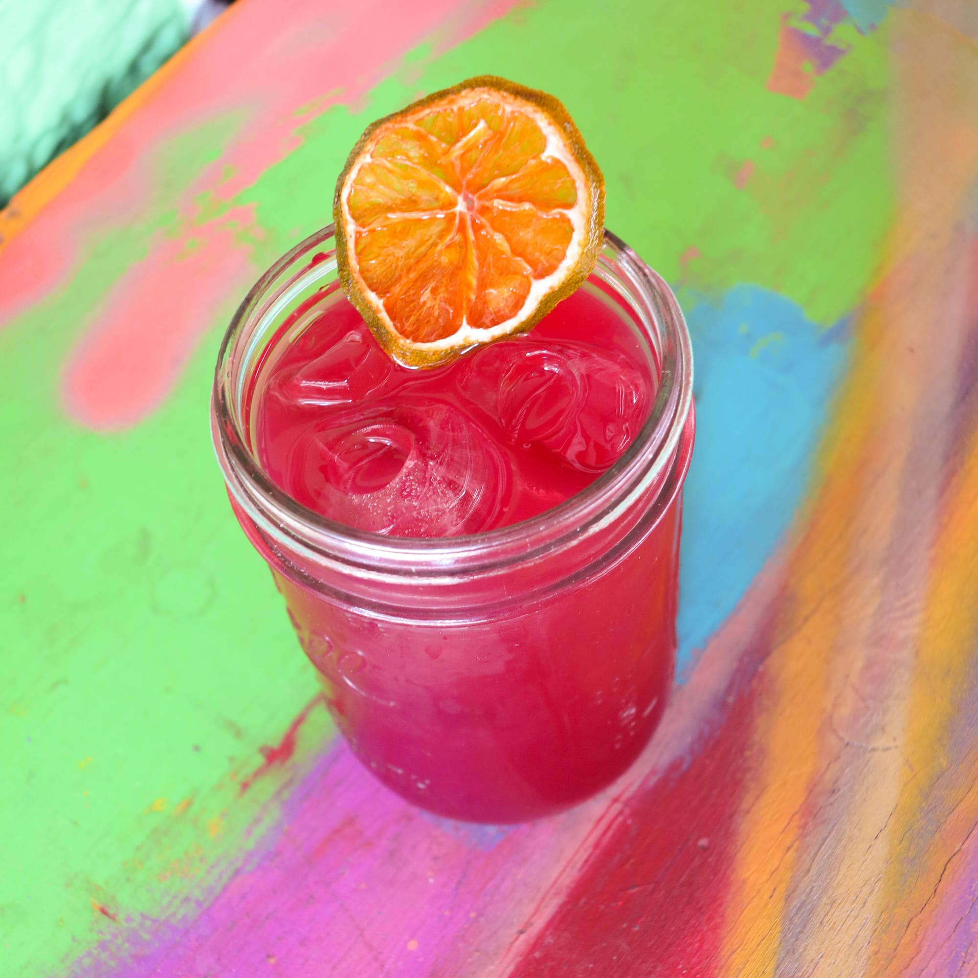 A pink-hued cocktail in a mason jar. 