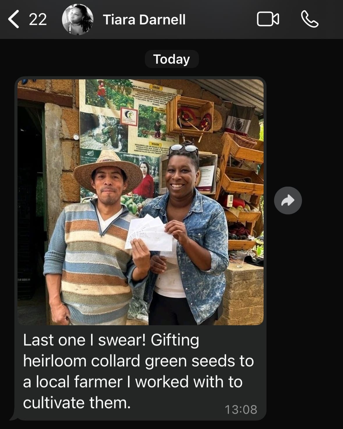A screenshot JD Shadel took of a message they received from Tiara Darnell. She has sent a photograph of herself posing with a farmer, one of her restaurant's suppliers. They're holding packets of seeds for collard greens.