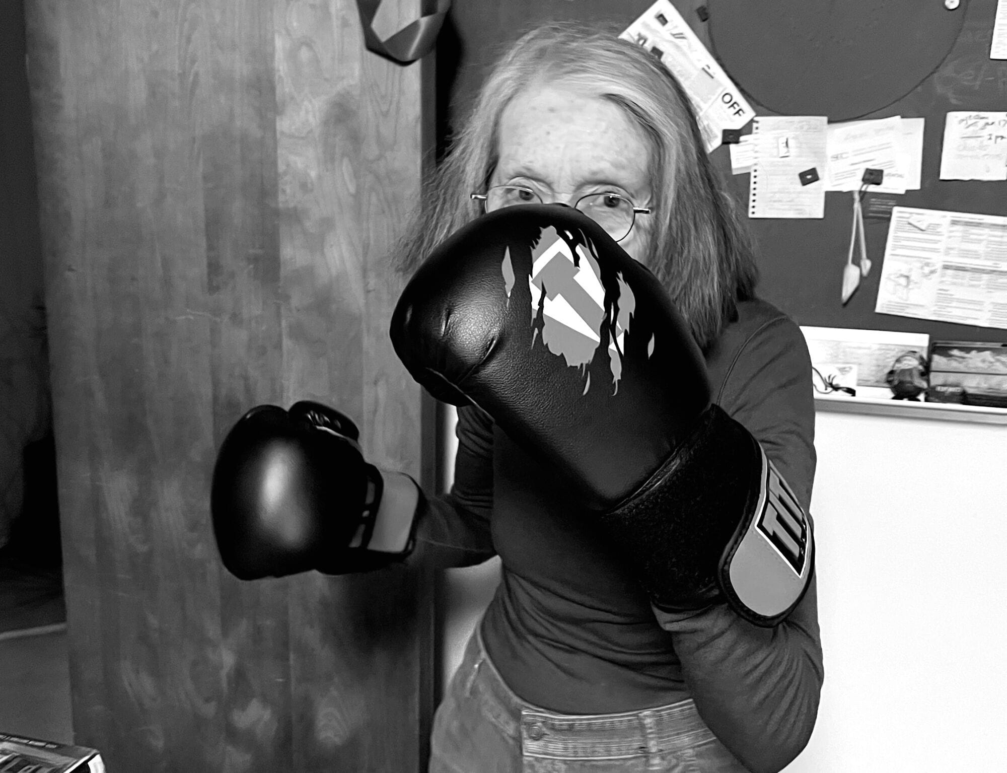 Anne Carson covers her face with a boxing glove.