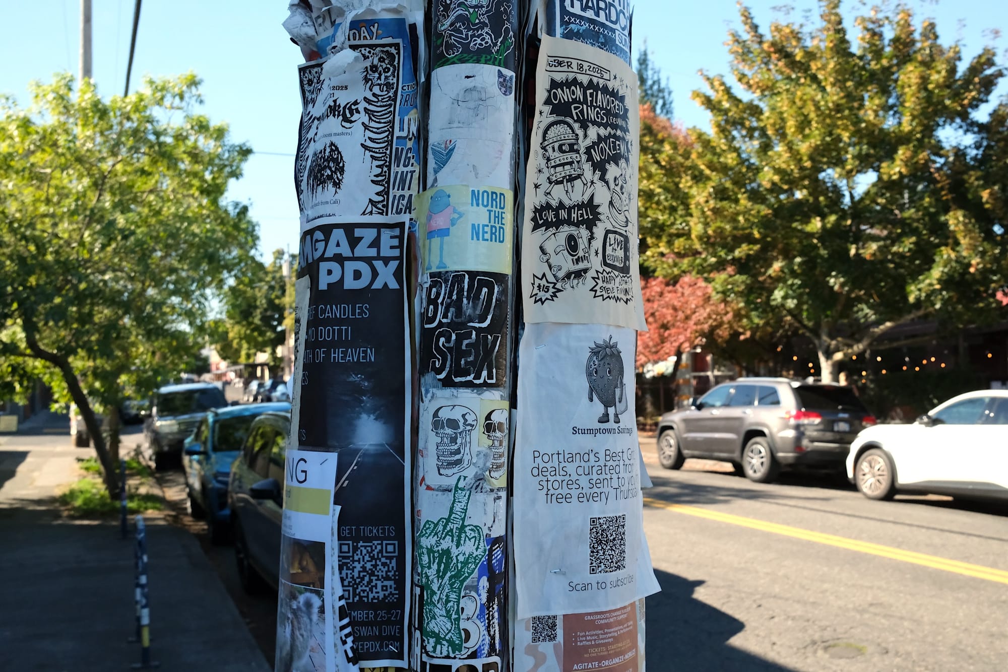 Surrounded by posters on one utility pole is this sticker, which reads "bad sex" in all caps.